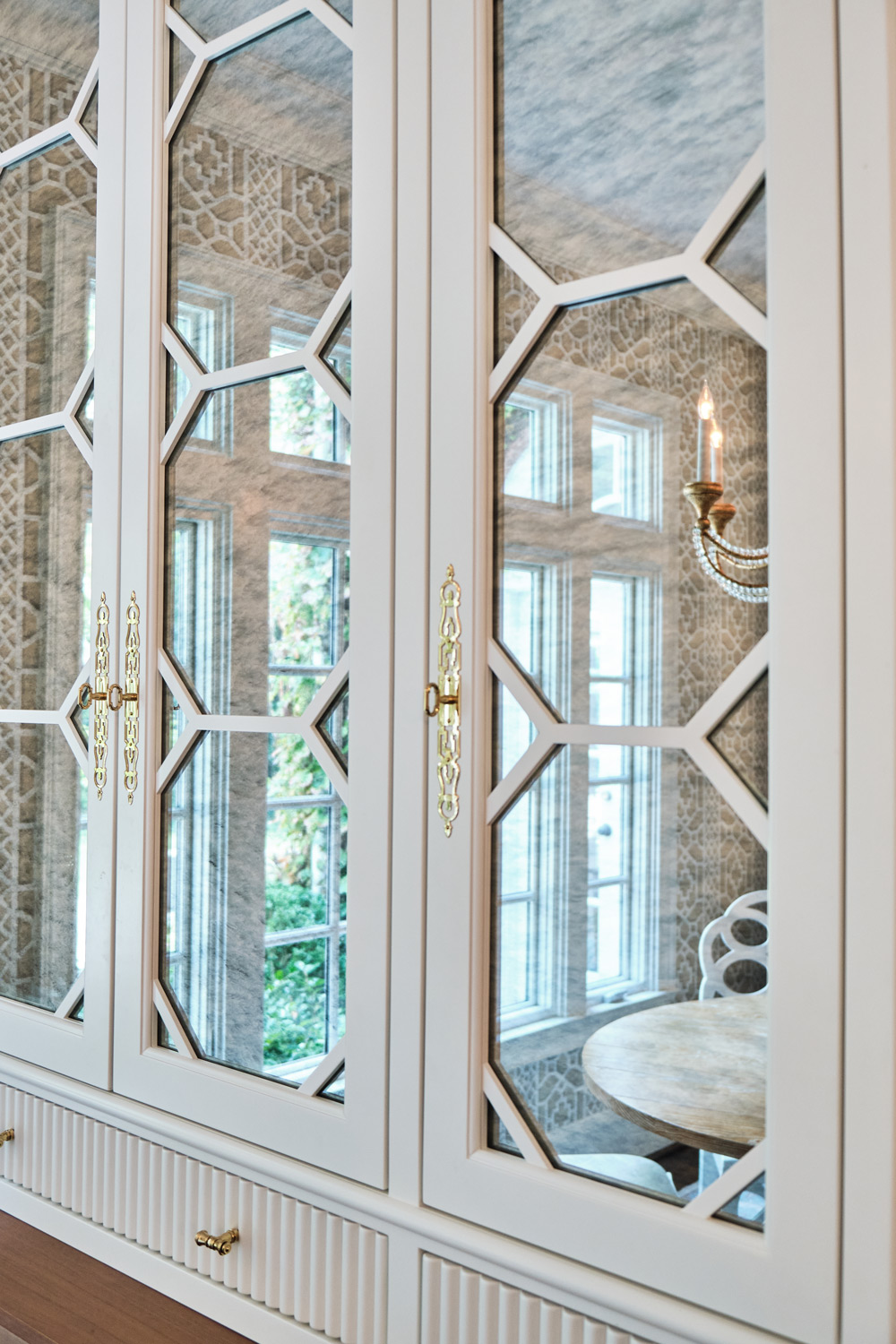a built in hutch on the opposite side of the breakfast nook has custom mirrored doors