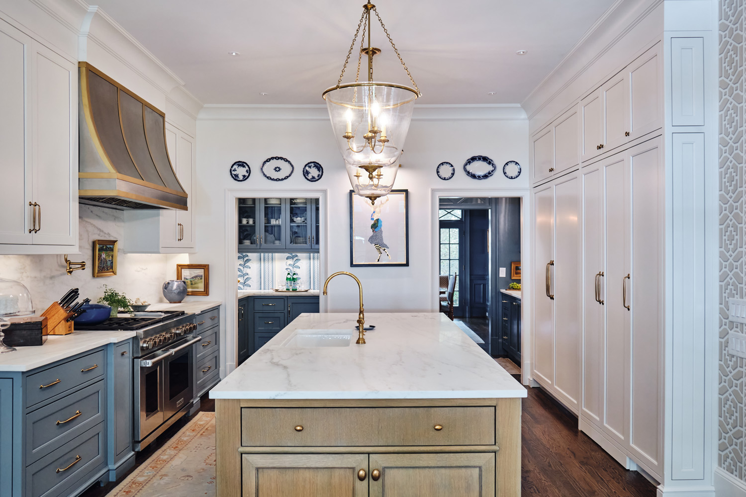 long view of the kitchen and island looking into the dining room and pantry