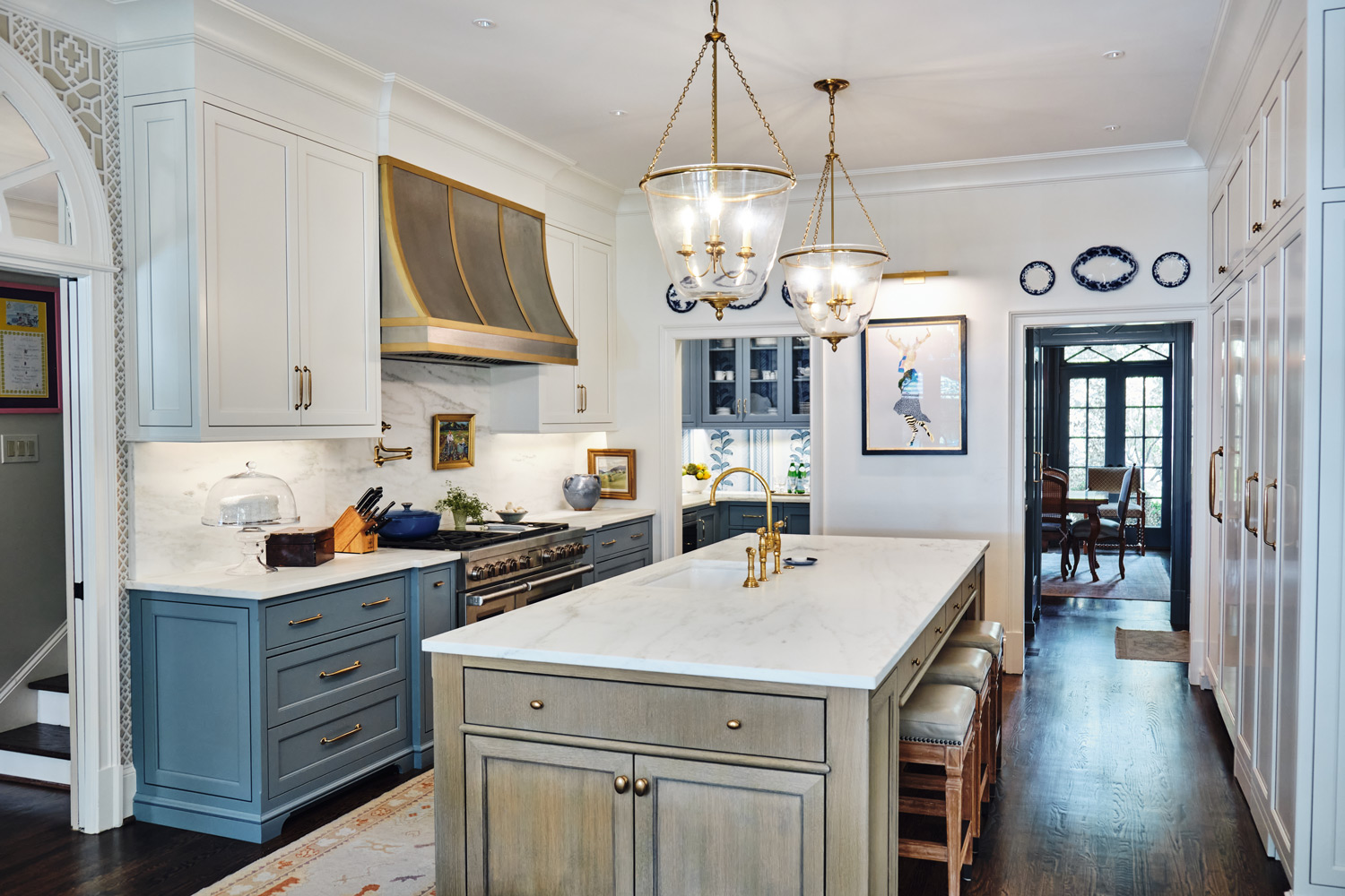 wide view of kitchen with blue and natural light wood cabinets looking back into the pantry and bar area