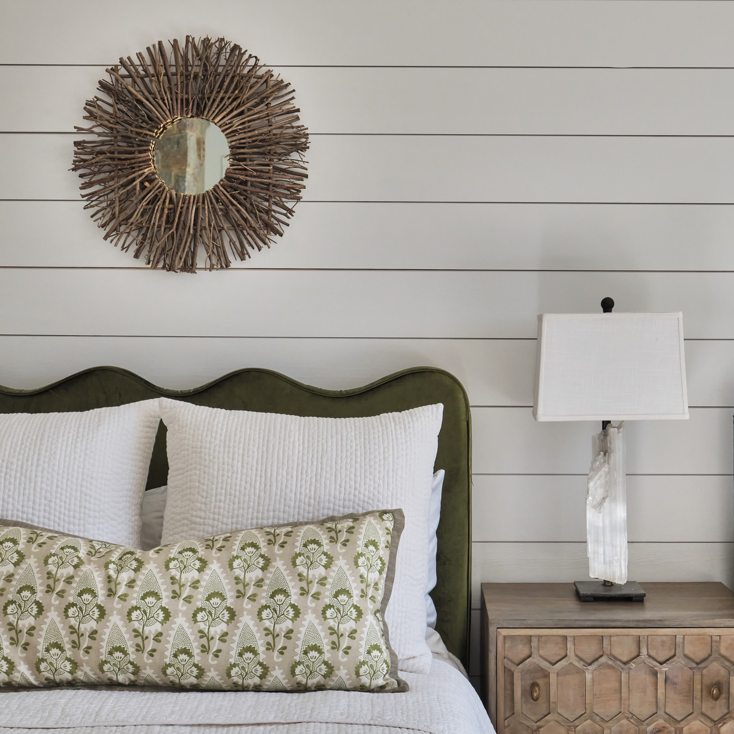 mirror decor over a green headboard on white shiplap walls