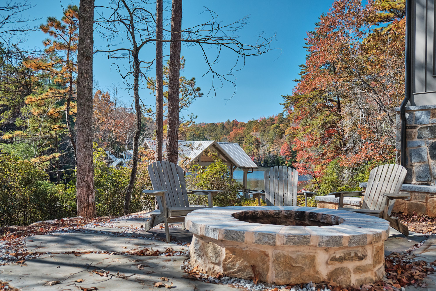 a firepit overlooks the lake and new boat house below
