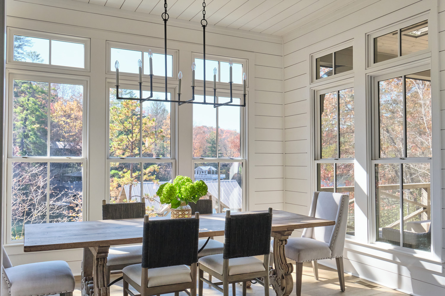 shiplap siding and an iron chandelier in the dining room