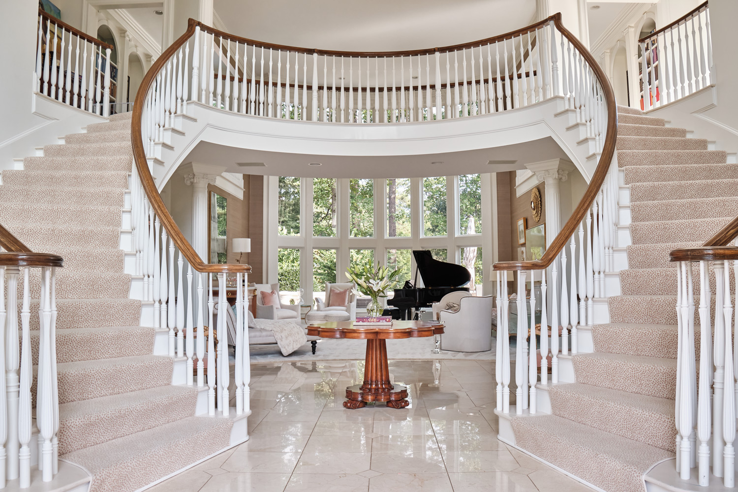 the grans staircase in the entryway with a peek at the living room behind