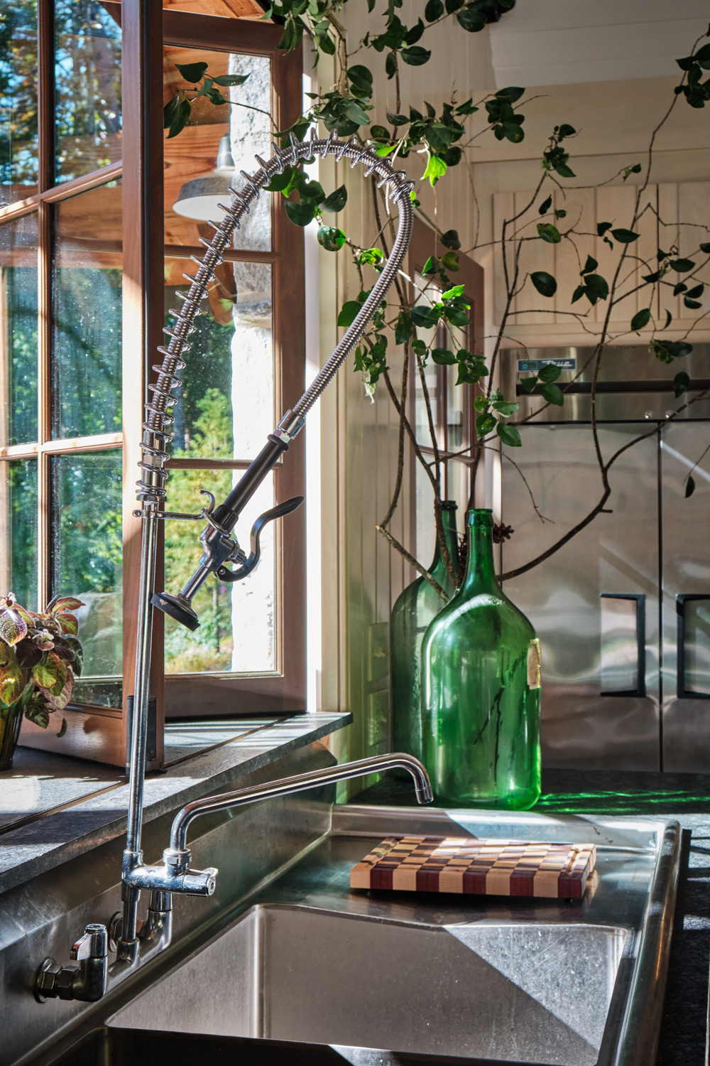 the industrial style stainless steel faucet in the pool house's kitchen