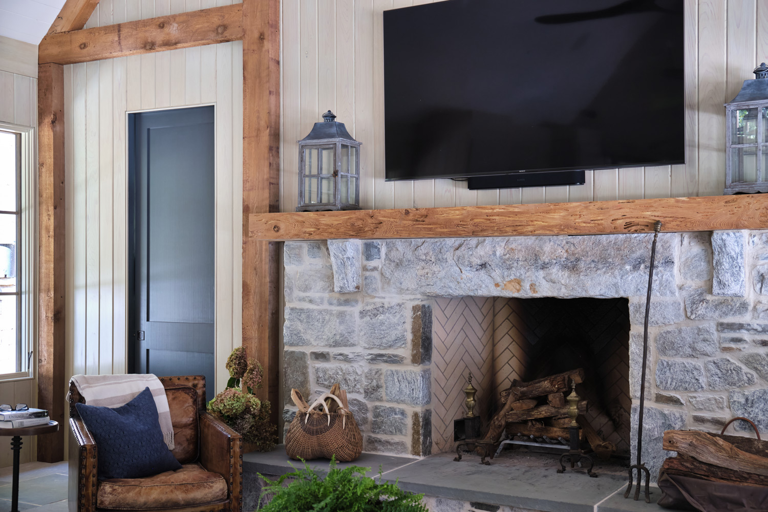 a blue door next to the fireplace carries the color into the living area of the pool house